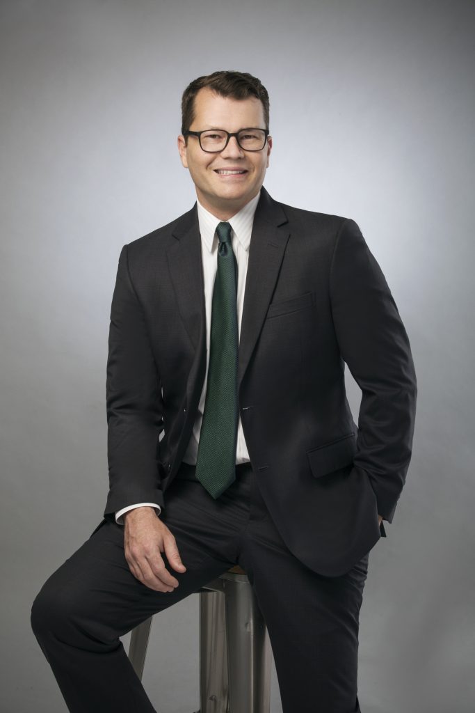 picture of man sitting on stool in business suit