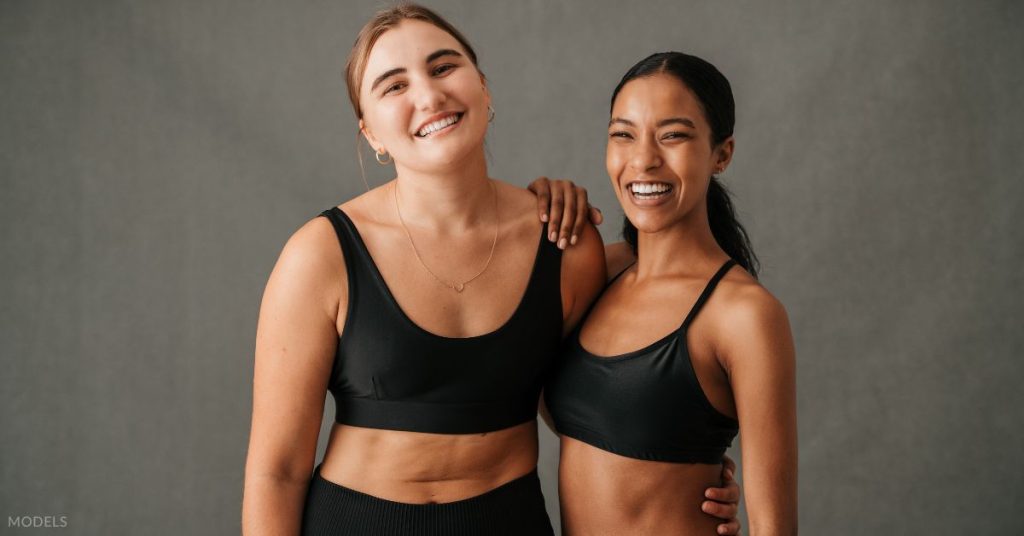Two women in fitness gear, posing together (models)