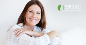 a smiling woman sitting on a white couch (model)